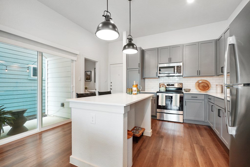 a kitchen with gray cabinets and a white island