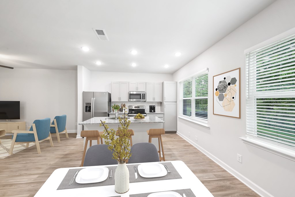 a living room and dining room with a table and chairs