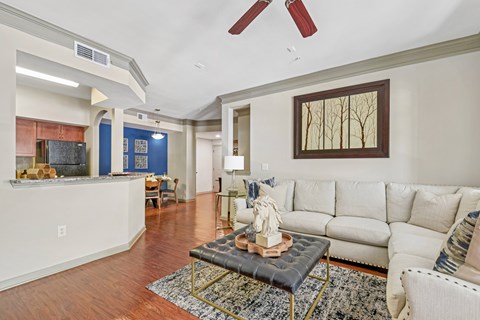 A living room with a white couch and a coffee table with a statue on it.