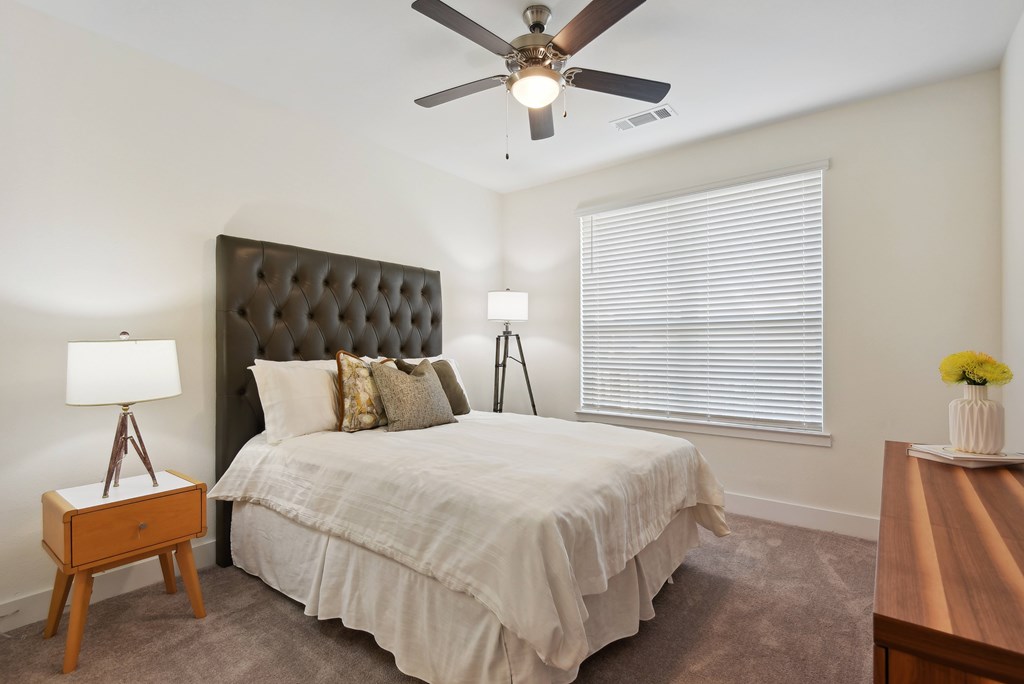 a bedroom with a large bed and a ceiling fan