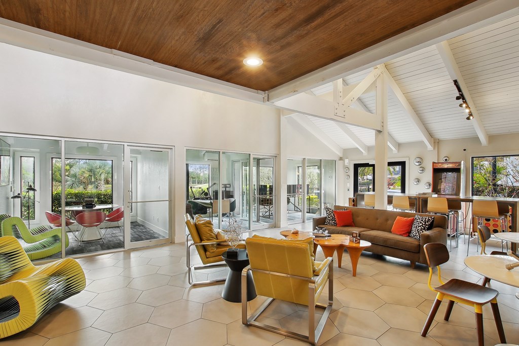 a living room with couches chairs and tables and glass doors