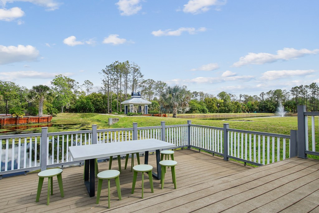 a picnic table on a deck overlooking a park with a gazebo