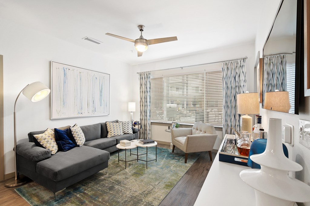 a living room with a couch and chairs and a large window