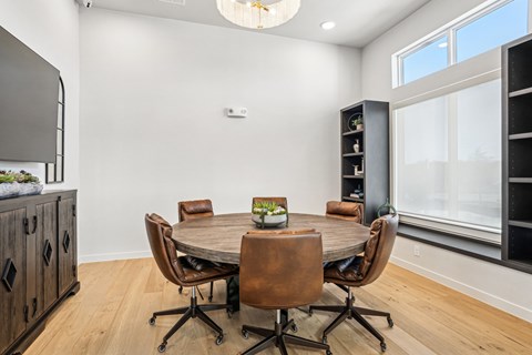 A dining room with a round table and chairs.