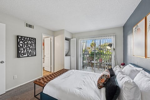 A bedroom with a large bed and a window with a view of the outside.