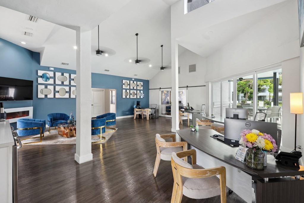 a living room with blue walls and a kitchen with a counter and chairs
