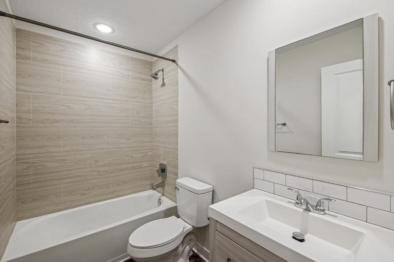 A white toilet sits next to a white sink in a bathroom.