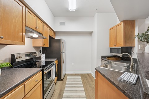 A kitchen with wooden cabinets and black appliances.
