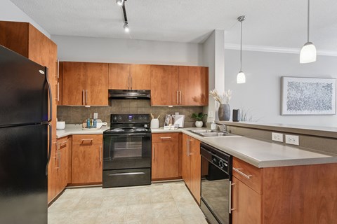 A modern kitchen with wooden cabinets and stainless steel appliances.