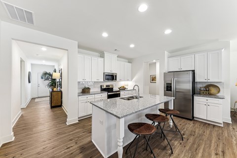 A modern kitchen with white cabinets and a central island.