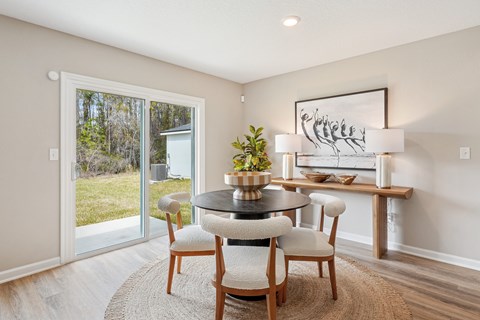 A dining room with a round table and chairs.