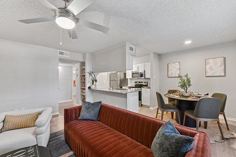 A living room with a red couch and a white chair.