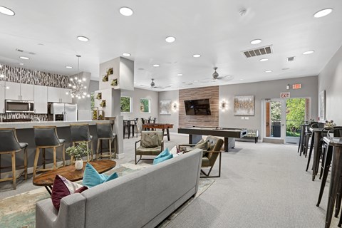 A modern living room with a grey couch and a bar area.