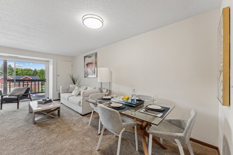 A dining room with a glass table and chairs.