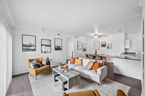 A living room with a grey couch, a coffee table, and a ceiling fan.