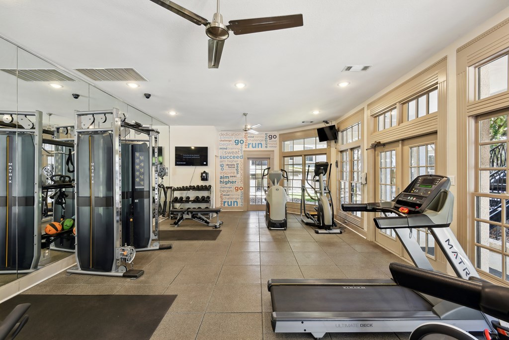 a workout room with a treadmill and other exercise equipment