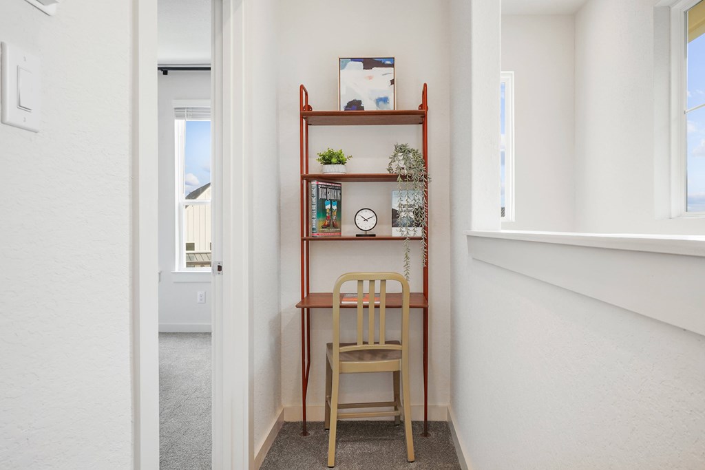 a chair and bookshelf in a corridor of a house