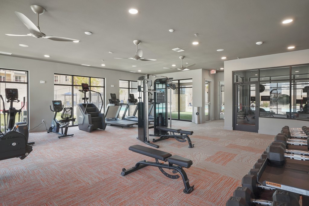 a spacious fitness center with cardio machines and other exercise equipment