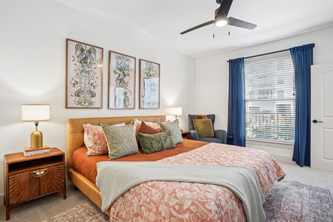 A bedroom with a large bed and a ceiling fan.