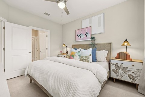 A bedroom with a large bed and a ceiling fan.