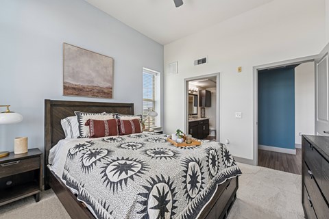 A bedroom with a large bed and a painting on the wall.