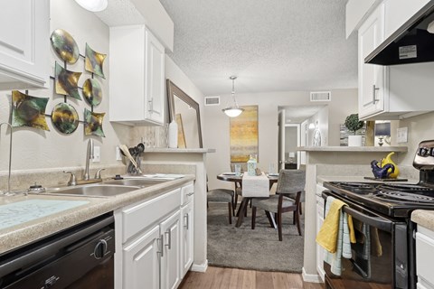 A kitchen with white cabinets and a black stove top oven.