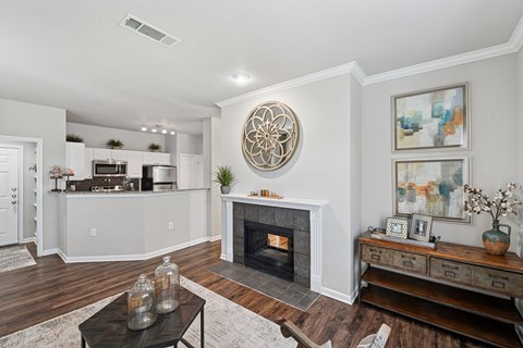 A living room with a fireplace and a large painting on the wall.