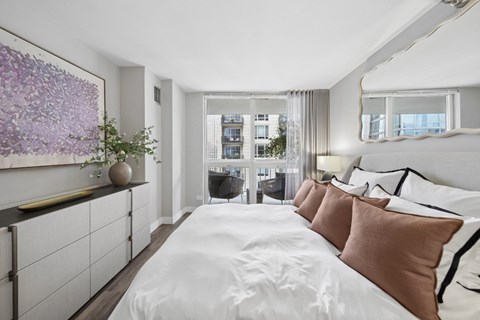 A bedroom with a large bed and a painting on the wall.