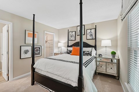 A bedroom with a four poster bed and a white bedspread.