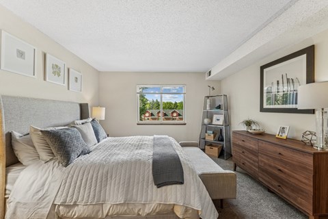 A bedroom with a large bed and a dresser.