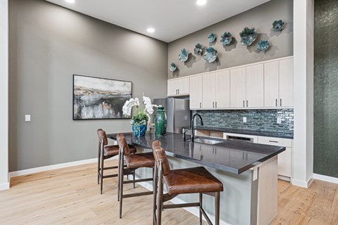 A kitchen with a table and chairs and a painting on the wall.