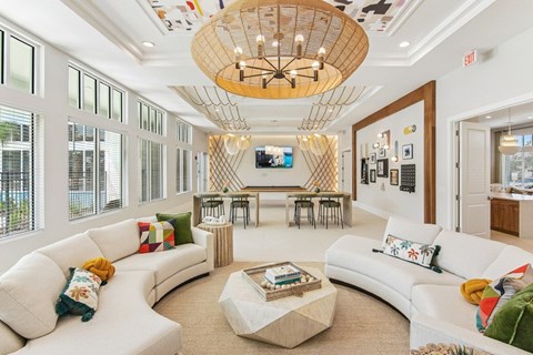 A living room with a white couch and a wooden chandelier.