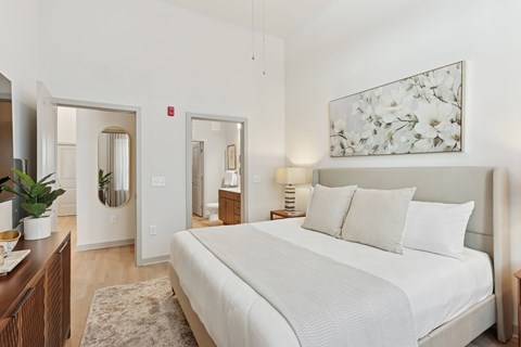A bedroom with a large bed and a painting on the wall.
