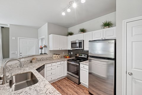 A kitchen with white cabinets and stainless steel appliances.