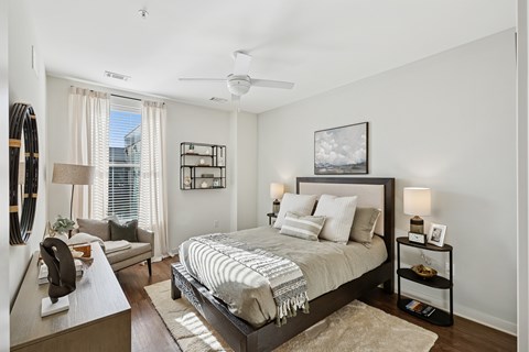 A bedroom with a large bed and a ceiling fan.