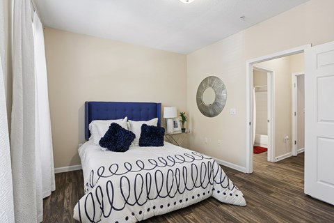 A bedroom with a bed and a mirror on the wall.