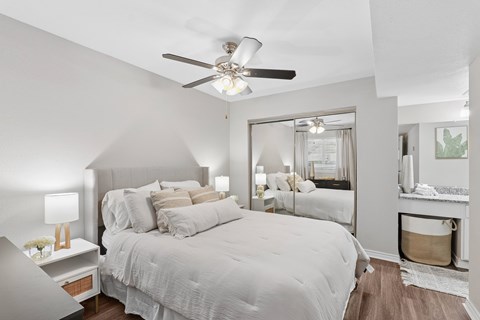 A bedroom with a large bed and a ceiling fan.