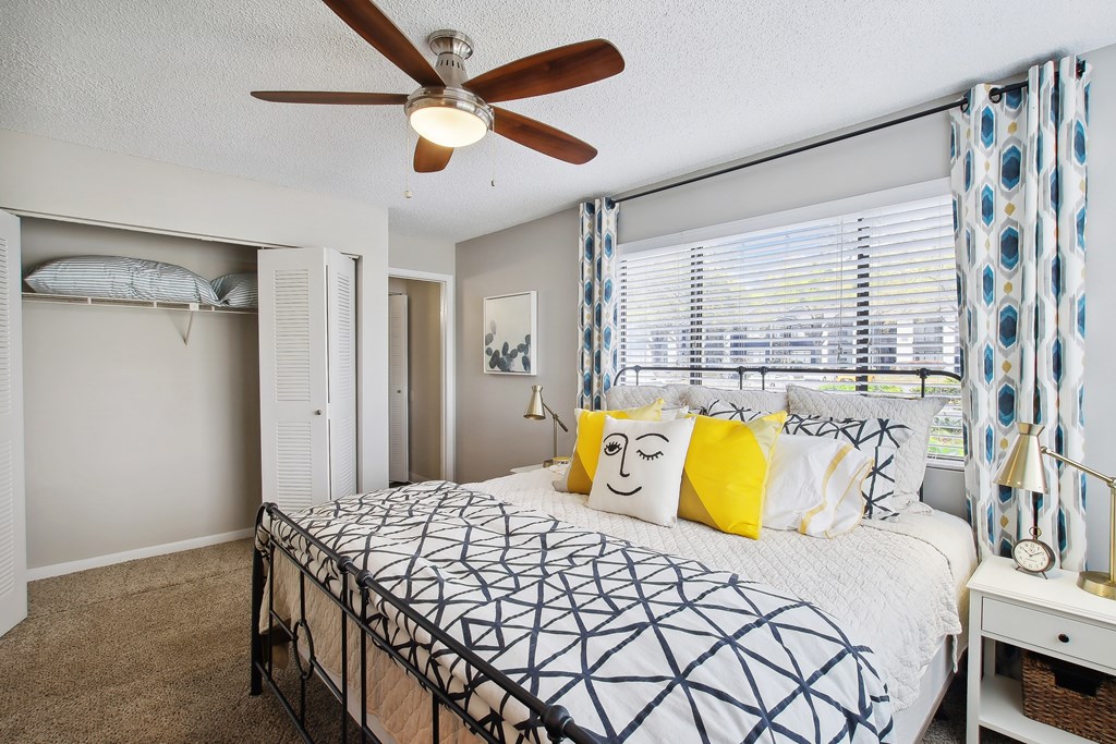 a bedroom with a large bed and a ceiling fan