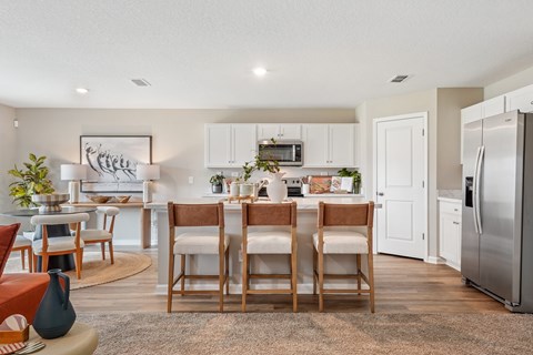 A kitchen with a dining table and chairs.