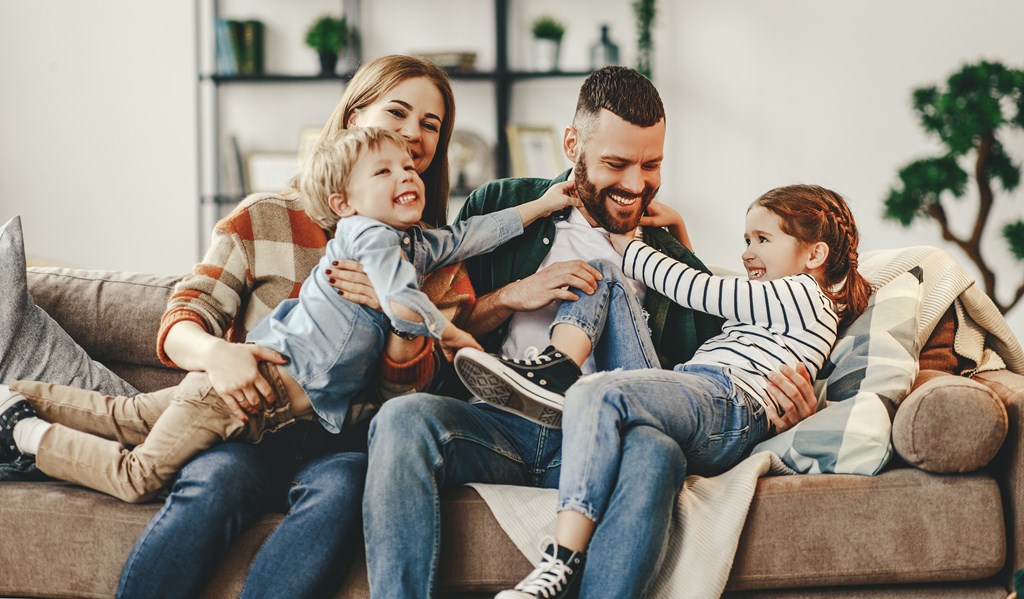 a family sitting on a couch with two children