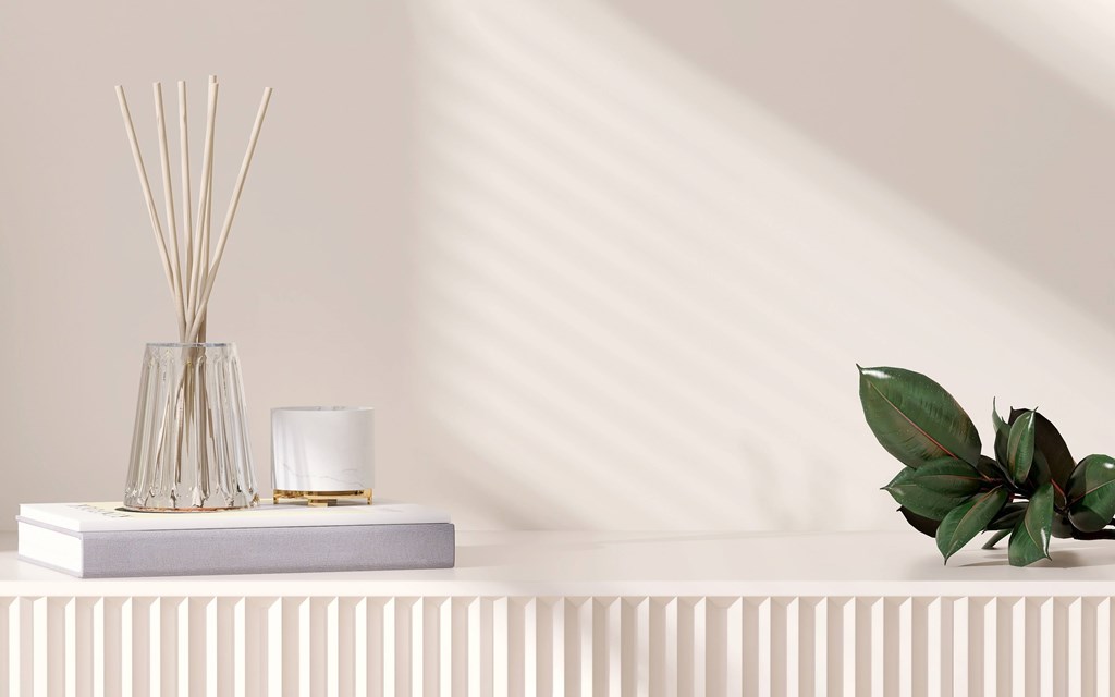 a vase with a plant and a candle on a shelf