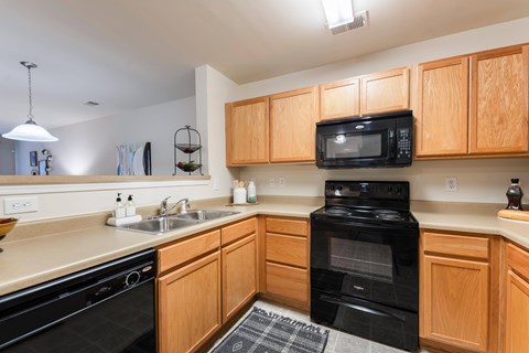 A kitchen with wooden cabinets and black appliances.