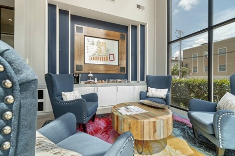 A living room with blue chairs and a wooden coffee table.