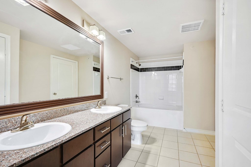a bathroom with two sinks and a shower and a toilet