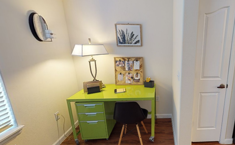 a desk with a lamp and a chair in a room