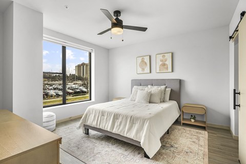 A bedroom with a large bed and a ceiling fan.