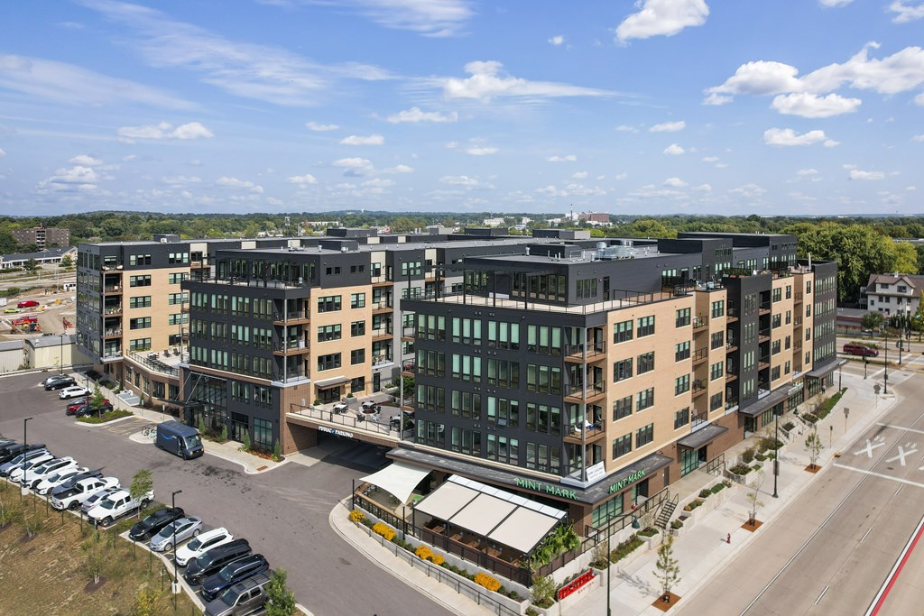 A modern building complex with a parking lot in front.