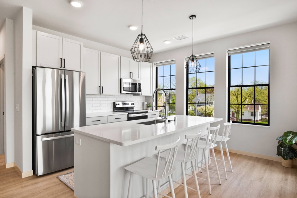A modern kitchen with white cabinets and a large island.