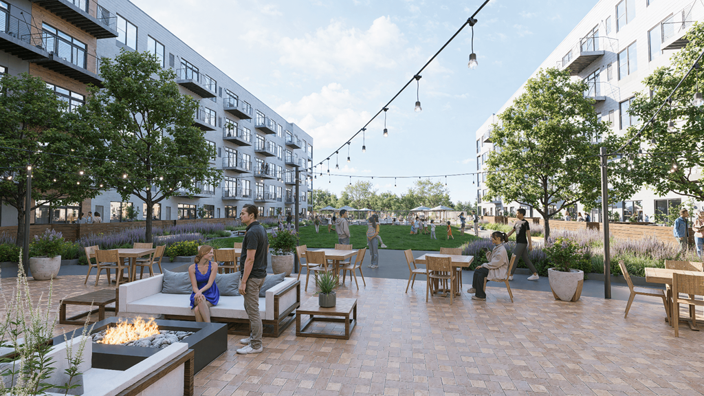 A group of people are sitting and standing around a fire pit on a patio.