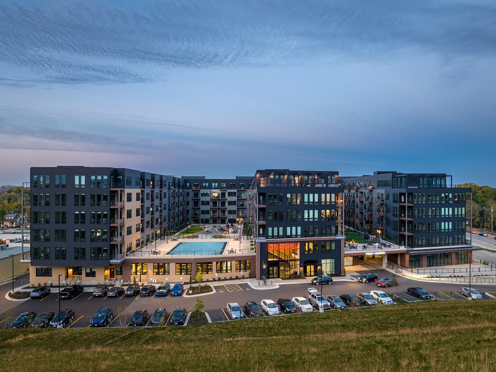 an aerial view of a building with a pool and parking lot